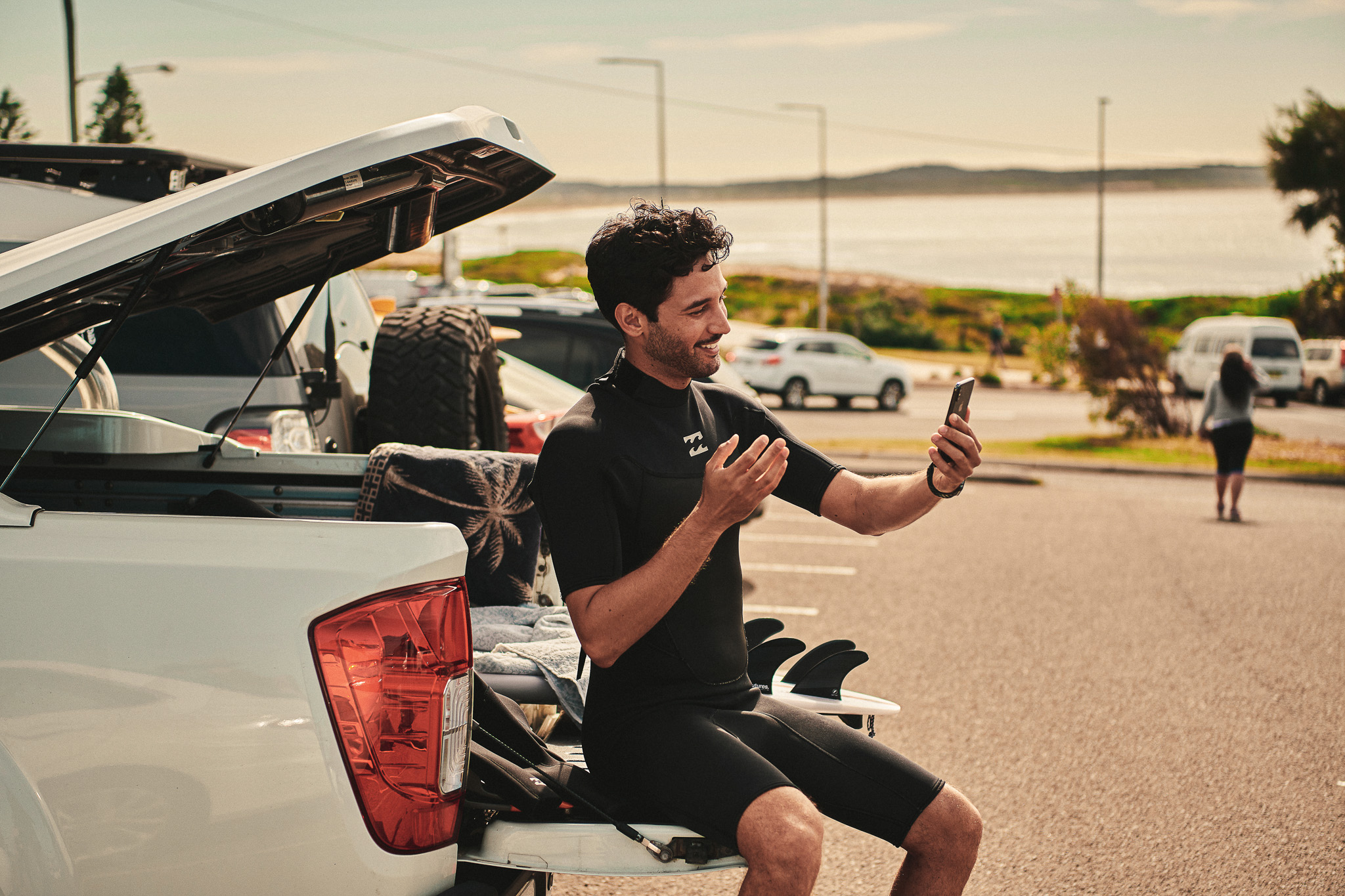 Image of Man Sitting on a Tailgate Holding his Phone